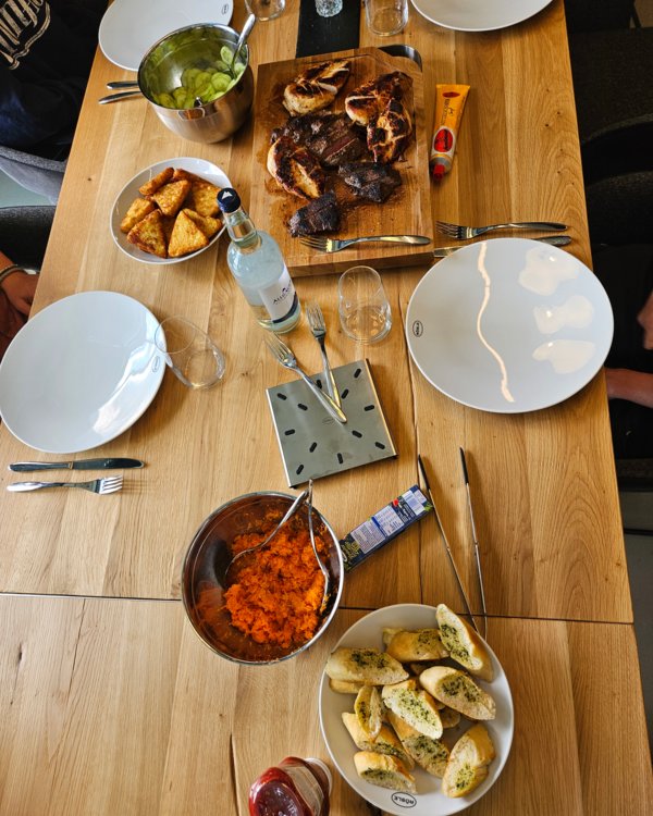 Gedeckter Tisch, auf dem Gurken und Karottensalat, Kräuter-Baguette, Kartoffelrösti und Steak stehen | © RÖSLE GROUP